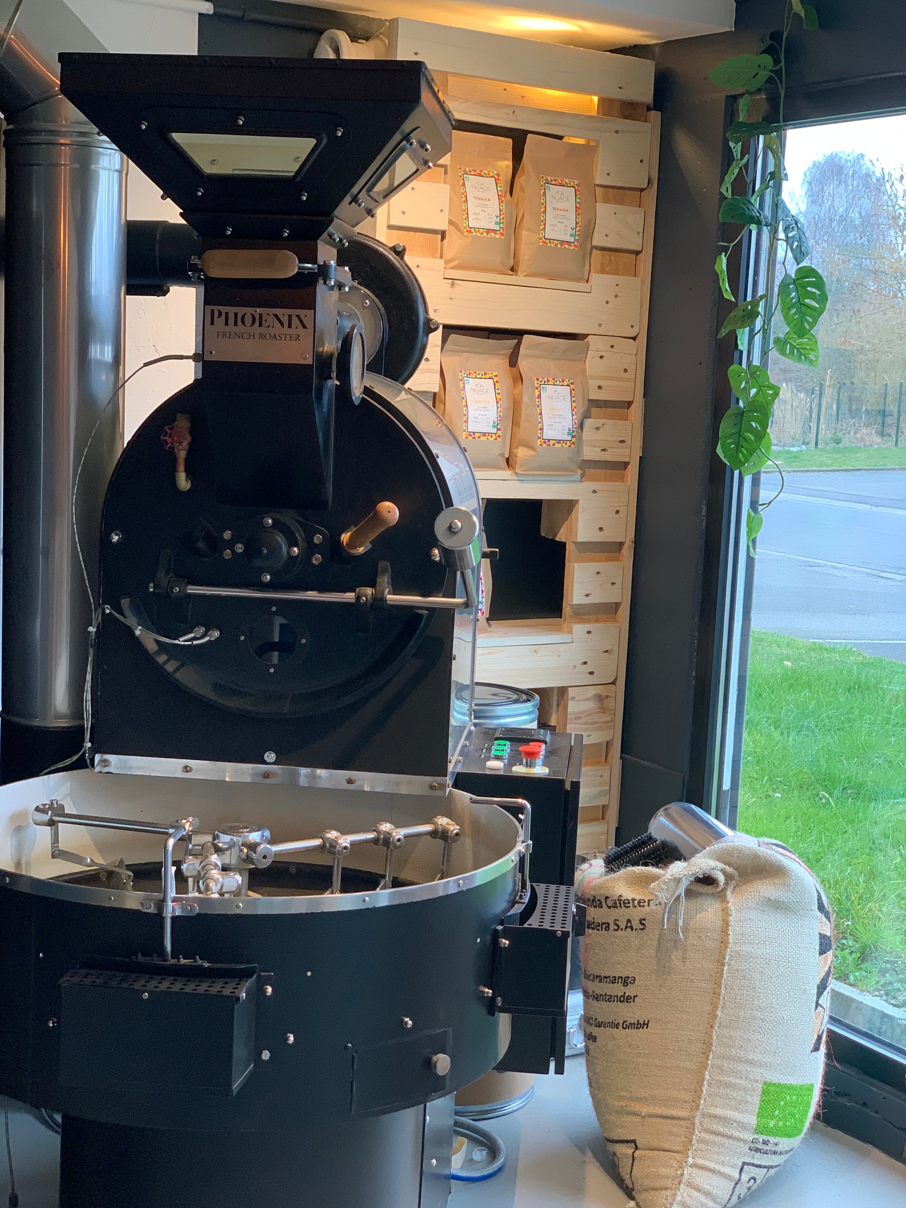 Machine de torréfaction avec sac de grains de café non torréfiés à côté et sachets de café prêts à la vente en arrière-plan – café de spécialité torréfié artisanalement à Hem, Nuage Coffee Roasters